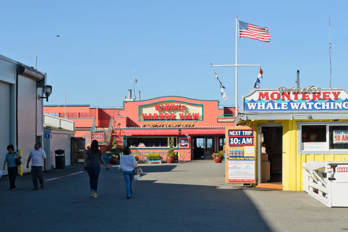 Colorful shops and Monterey whale-watching sign on Old Fisherman’s Wharf in Monterey, California. Destination photo. Not the club or its route.