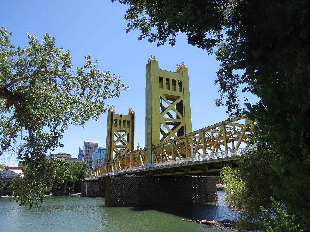 Golden Tower Bridge spanning the Sacramento River, photographed from the west bank toward Sacramento Destination photo. Not the club or its route.