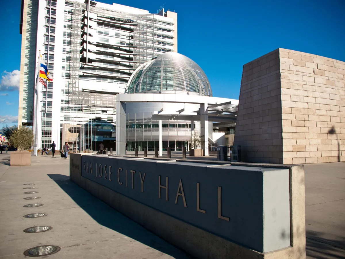 San Jose City Hall sign in front of the glass rotunda and modern white tower in San Jose, California. Not the club or its route.