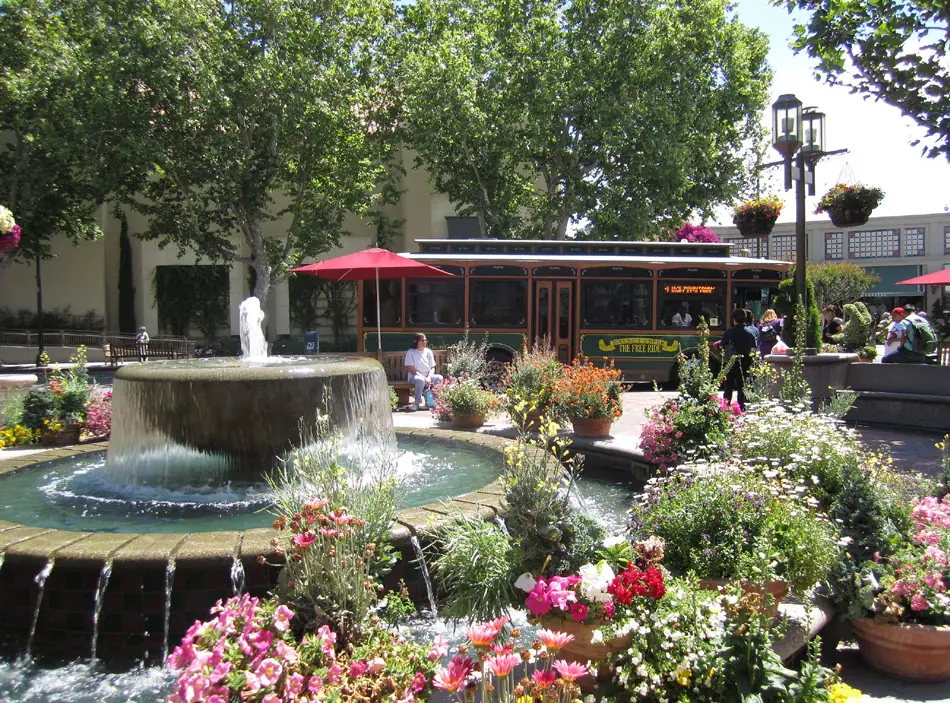 Flower-lined fountain and historic trolley-style shuttle at Broadway Plaza in downtown Walnut Creek Destination photo. — destination photo, not the race course
